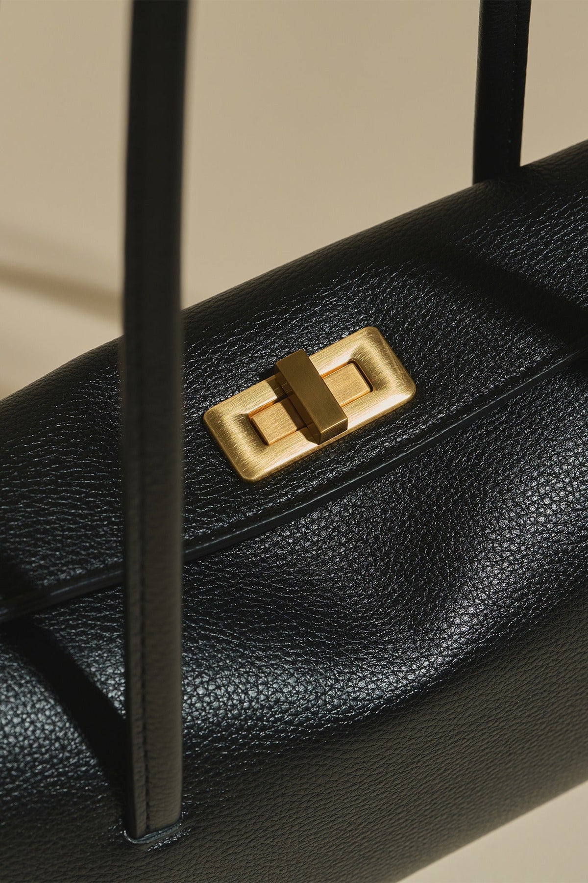 Close-up of MJade\u2019s brushed gold rectangular buckle.